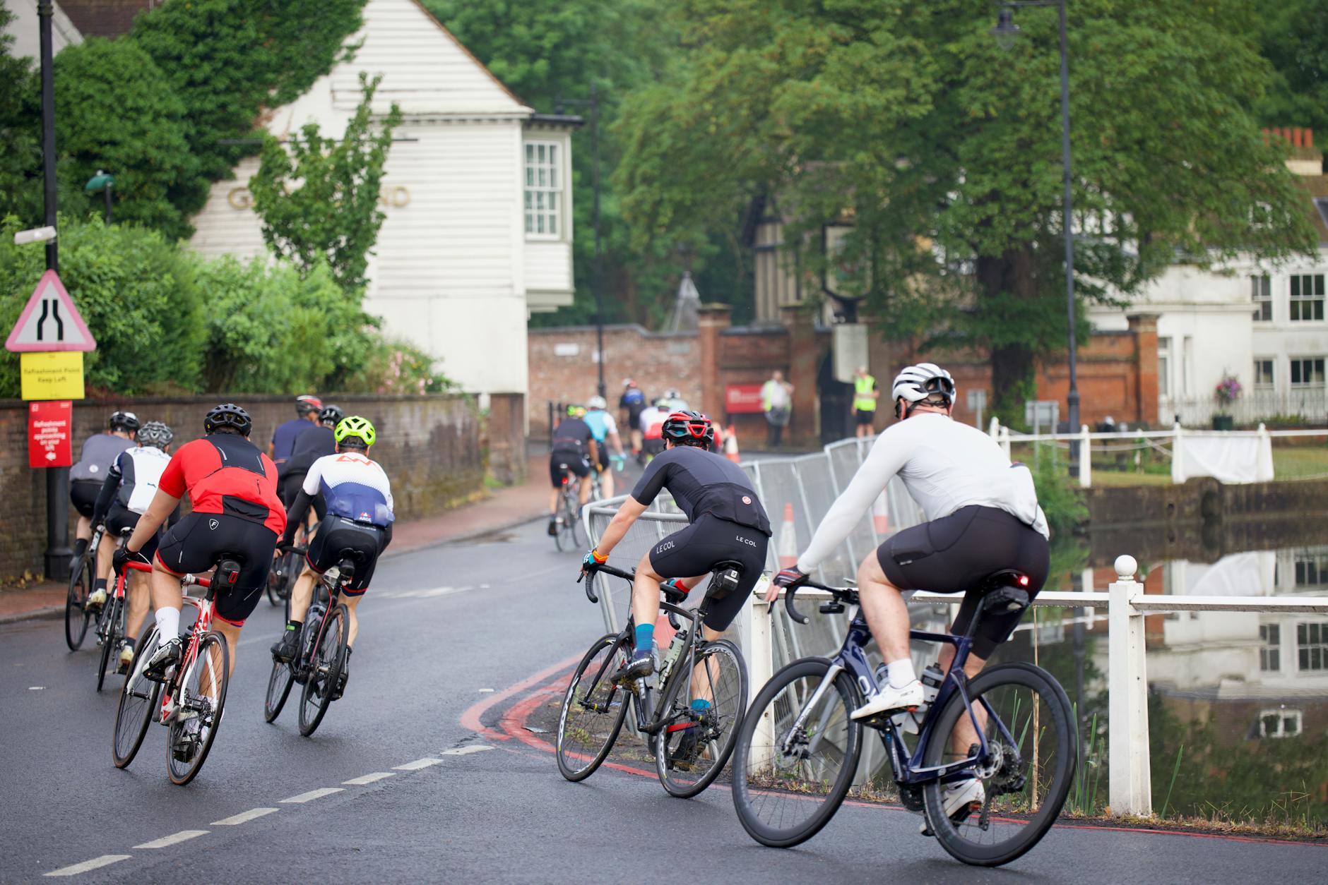 Uczestnicy charytatywnego rajdu rowerowego jadą drogą wśród zieleni