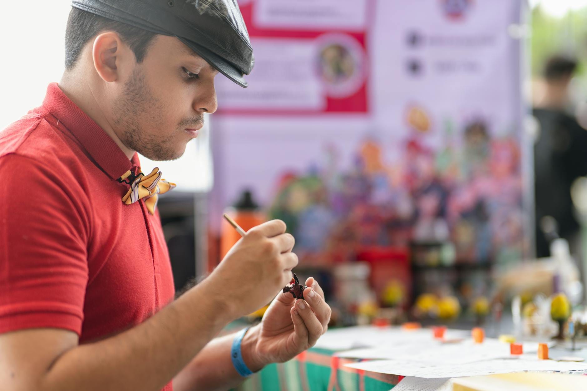 Cosplayer malujący figurki anime na wydarzeniu artystycznym w San José