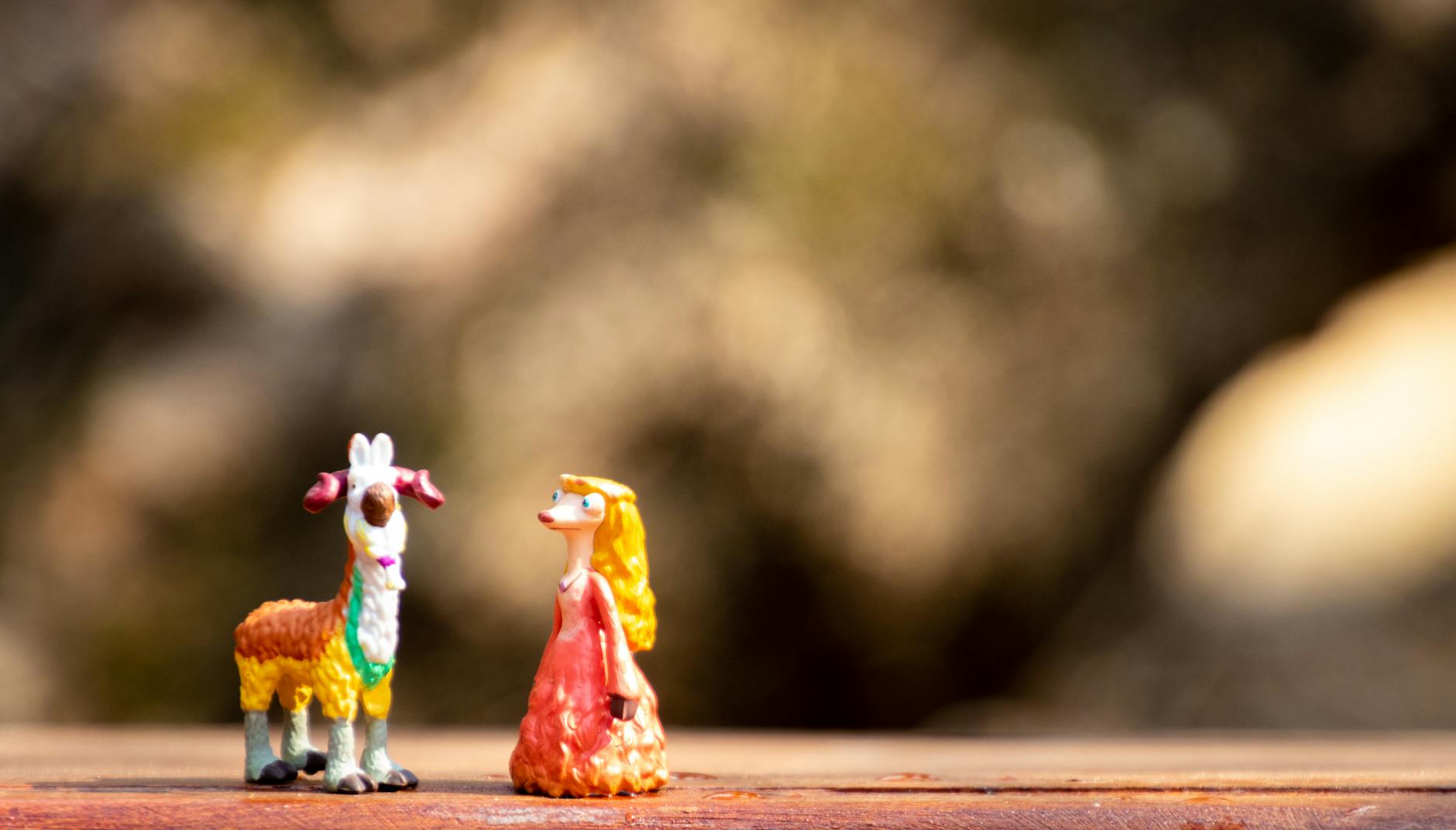 Jak ograniczyć kurz na kolekcji: triki z gablotą, pędzlem i filtrami Figurki kozy i postaci kolekcjonerskich ustawione na drewnianym blacie