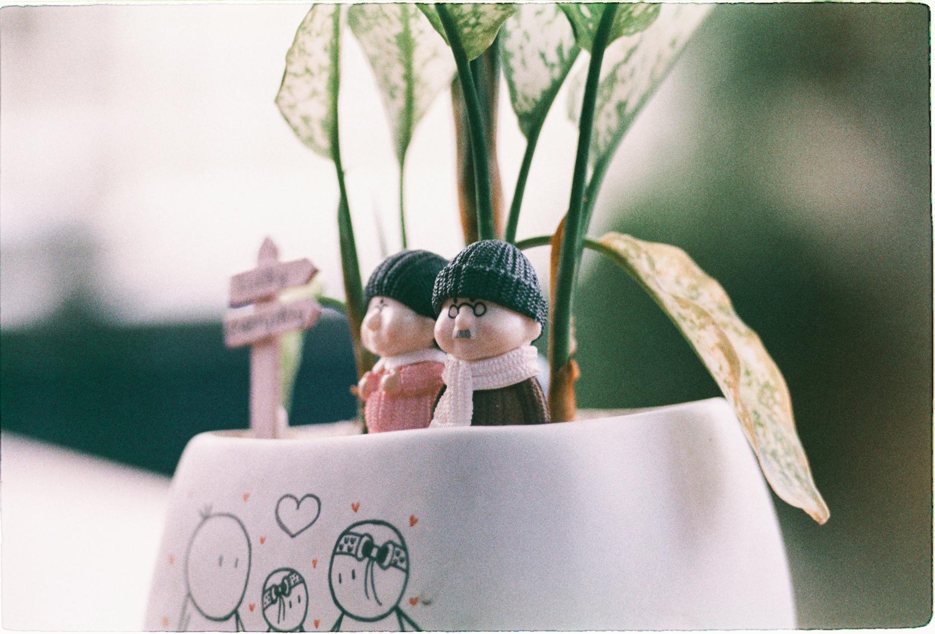 Miniaturowa para figurek w doniczce z rośliną jako przytulna dekoracja