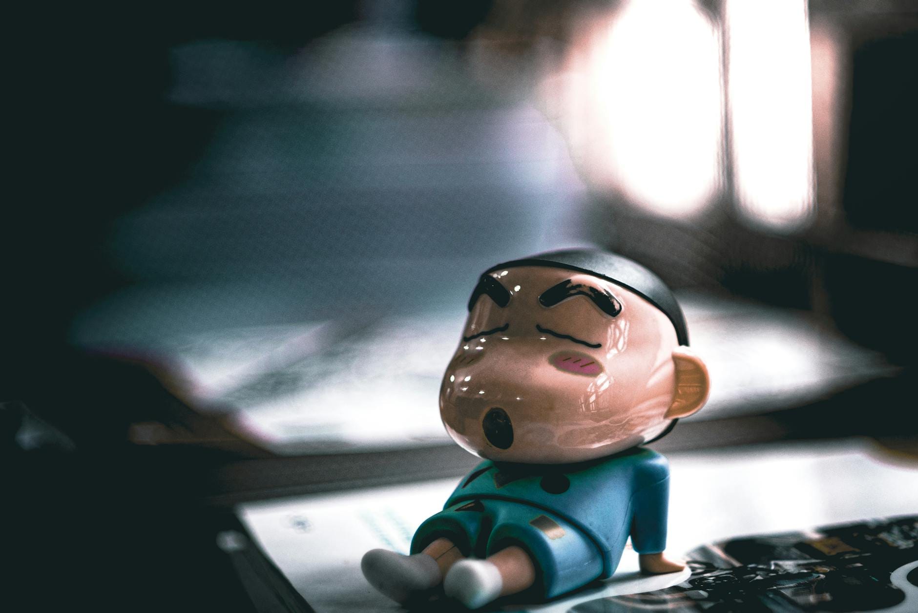 Zbliżenie figurki w stylu chibi śpiącej na stole w miękkim świetle