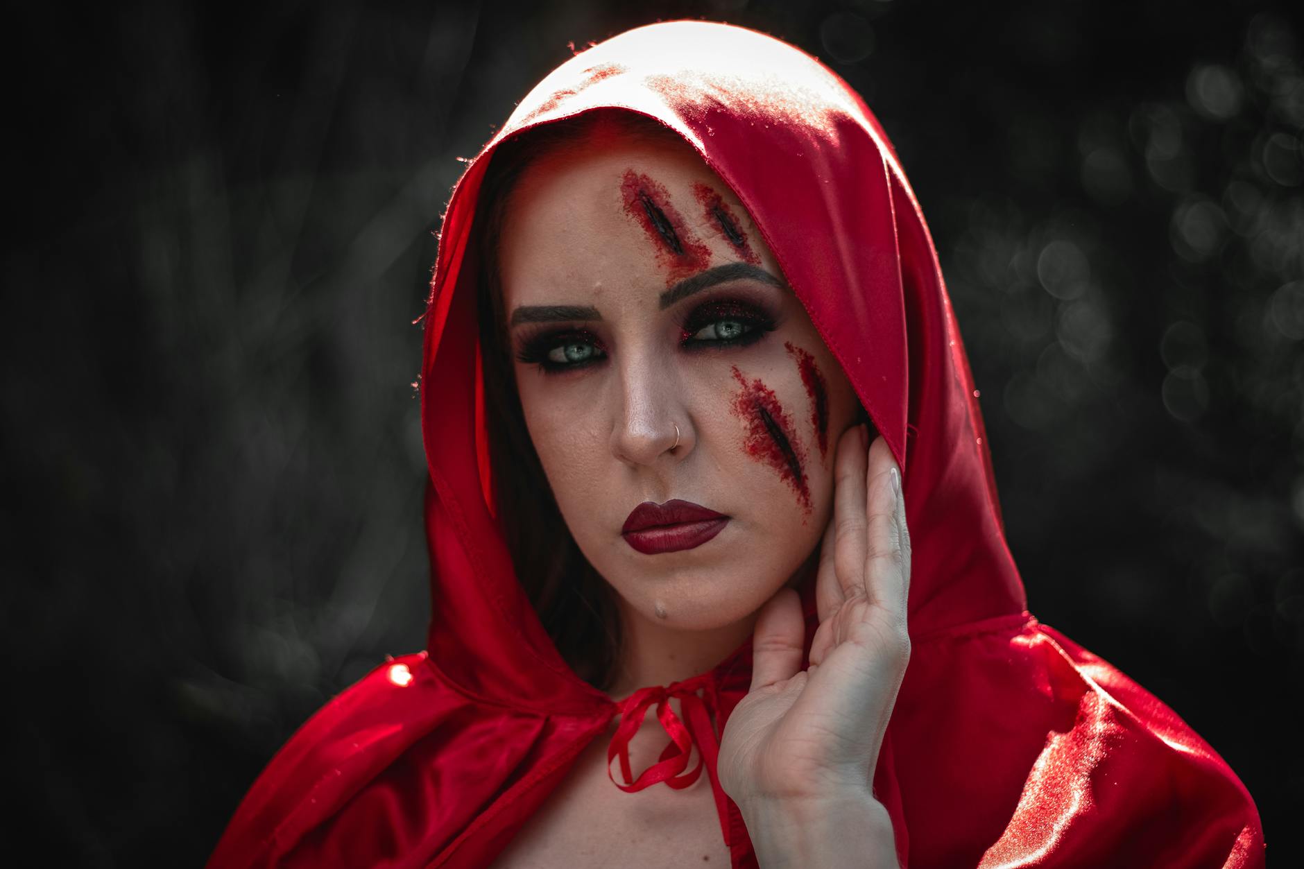 Kobieta w czerwonym kapturze z realistycznymi bliznami cosplay