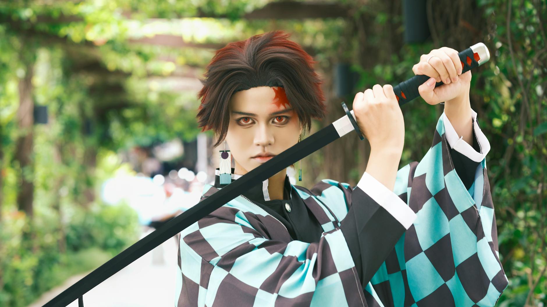 Cosplayer z kataną w zielonym plenerze nawiązuje do honoru w anime