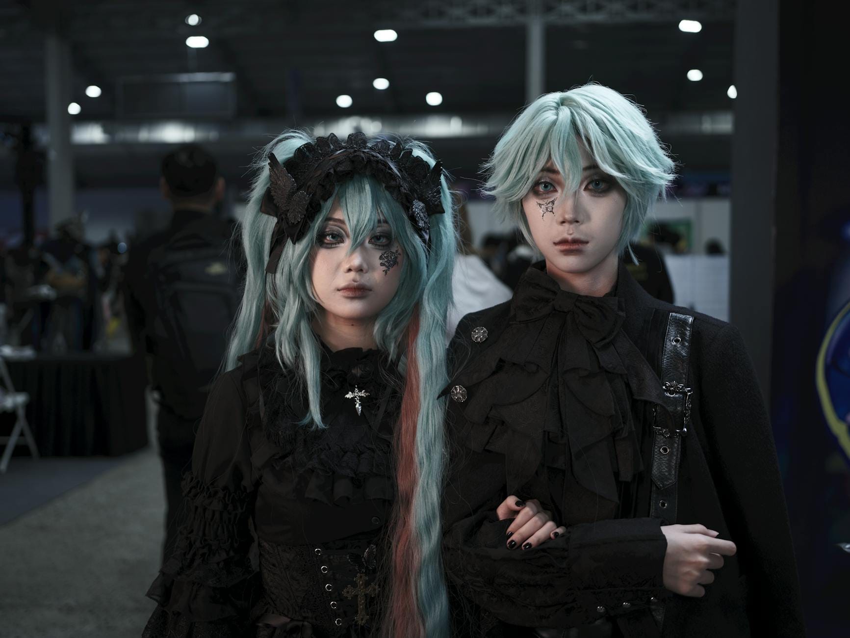 Dwoje osób w gotyckim cosplayu na konwencie anime w hali