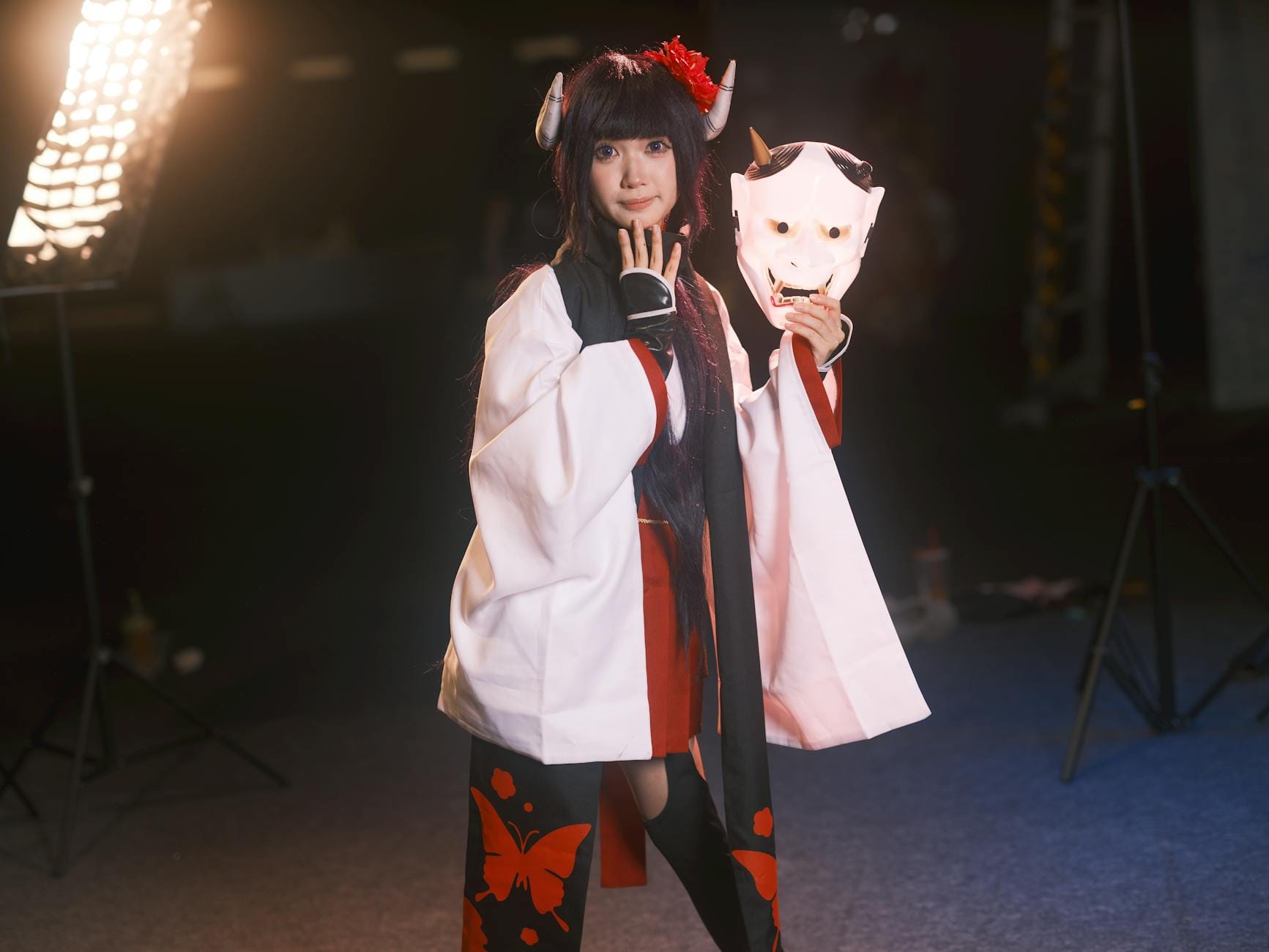 Cosplayer w tradycyjnym stroju trzymający maskę oni w studiu