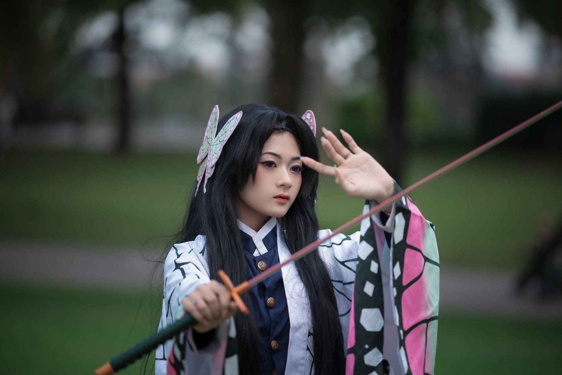 Cosplayer z mieczem pozuje w spokojnym parku