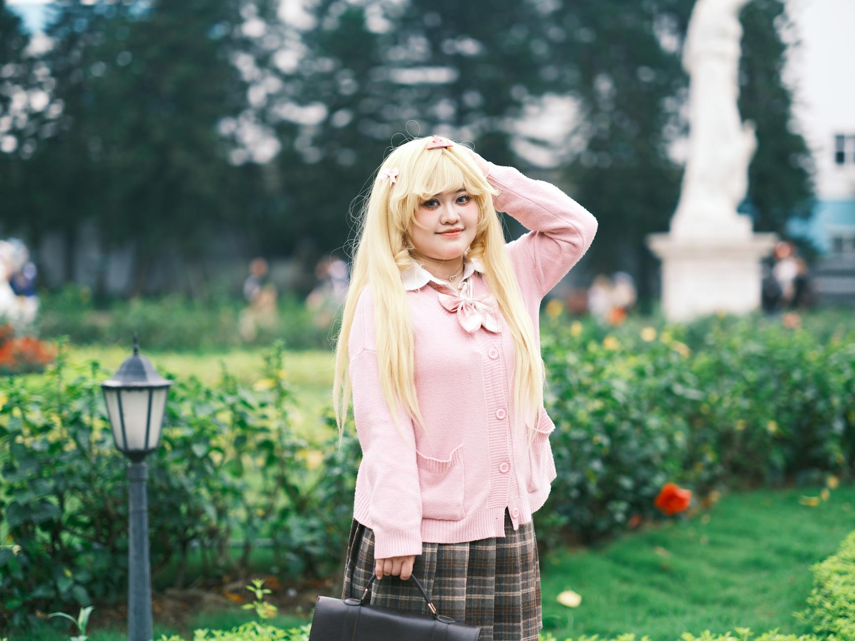 Cosplayerka w różowej stylizacji kawaii pozuje w ogrodzie w Wietnamie