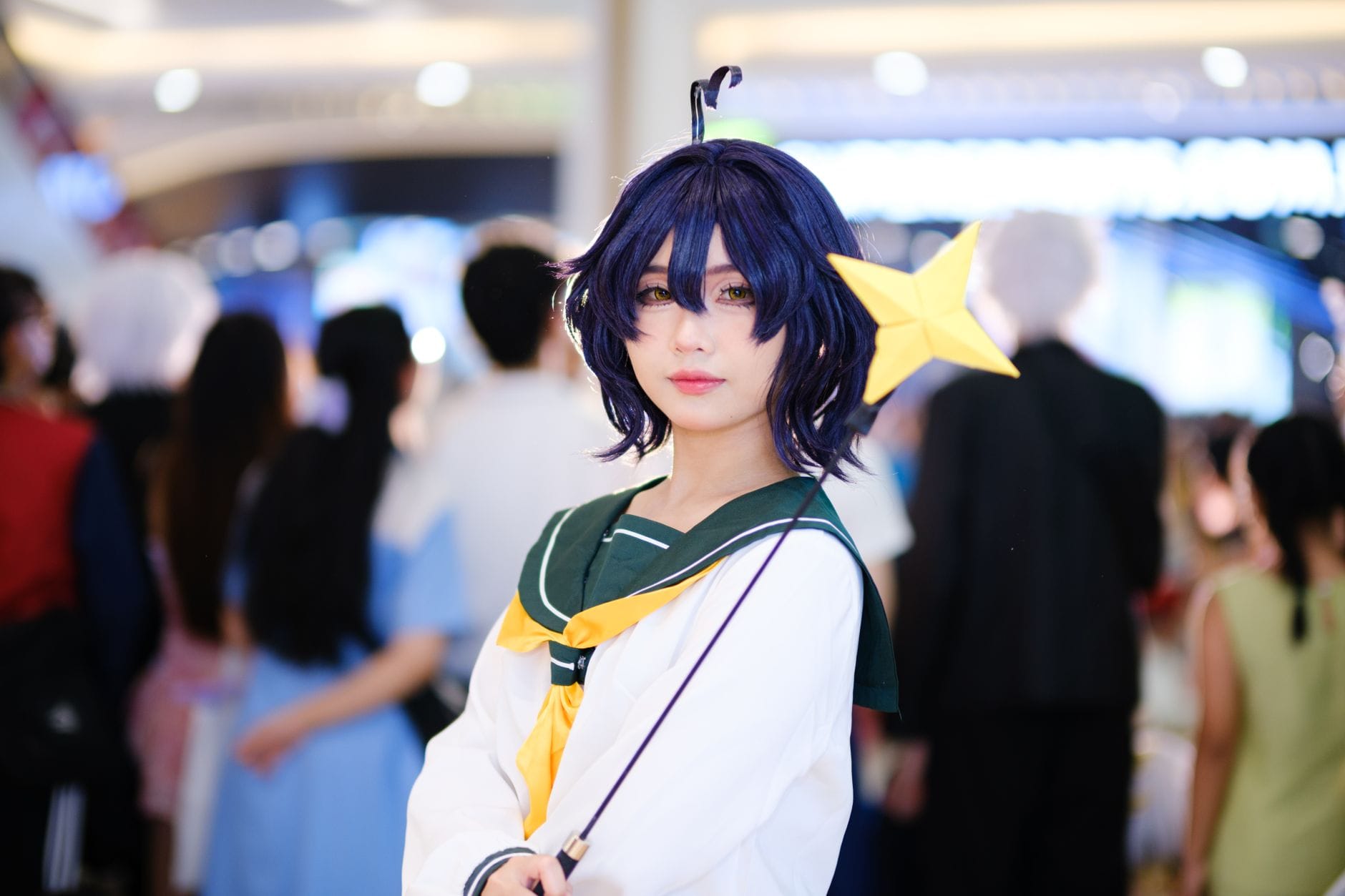 Cosplayerka z różdżką w kształcie gwiazdy na zatłoczonym konwencie