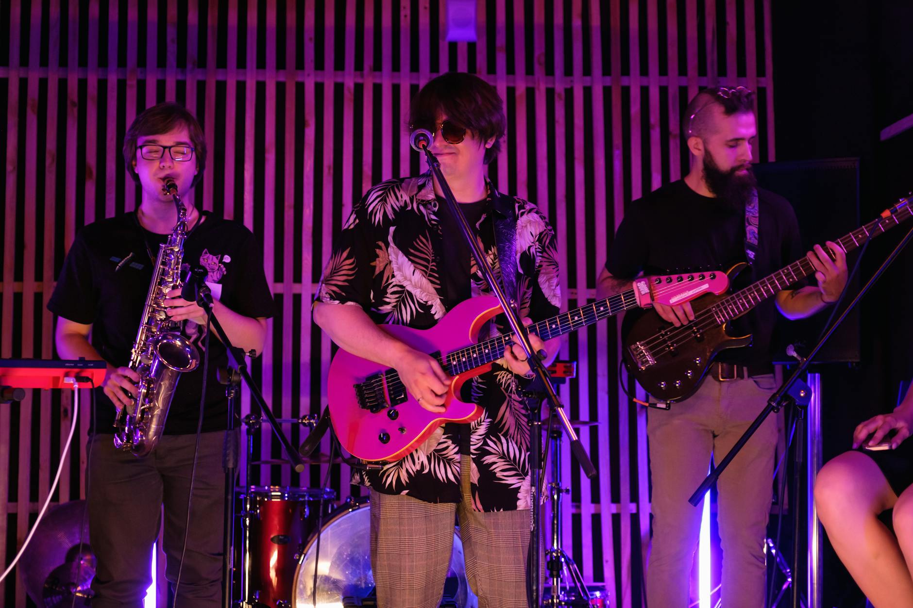 Energetyczny koncert zespołu z gitarą elektryczną, saksofonem i basem