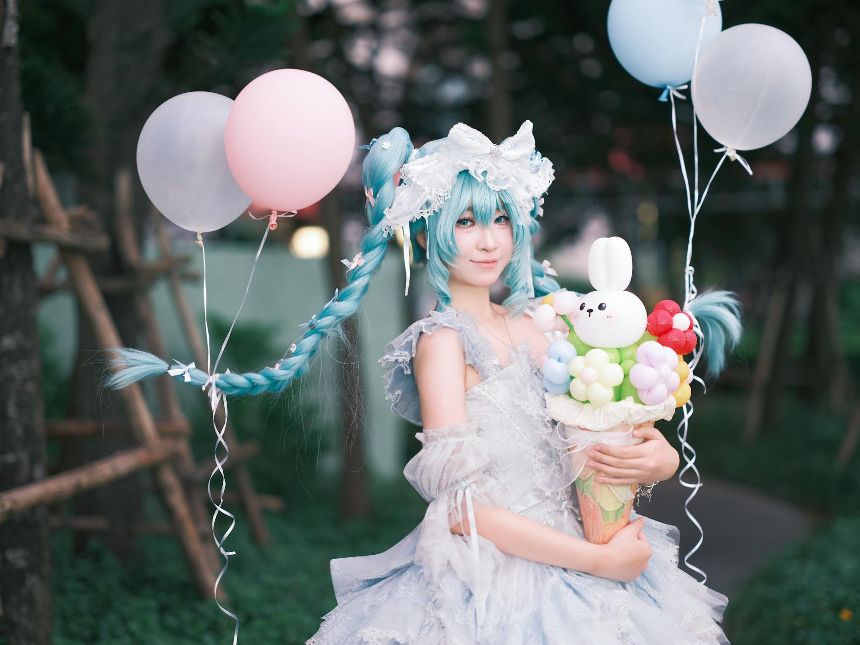 Osoba w kawaii cosplayu trzyma balony i kolorowy bukiet na dworze