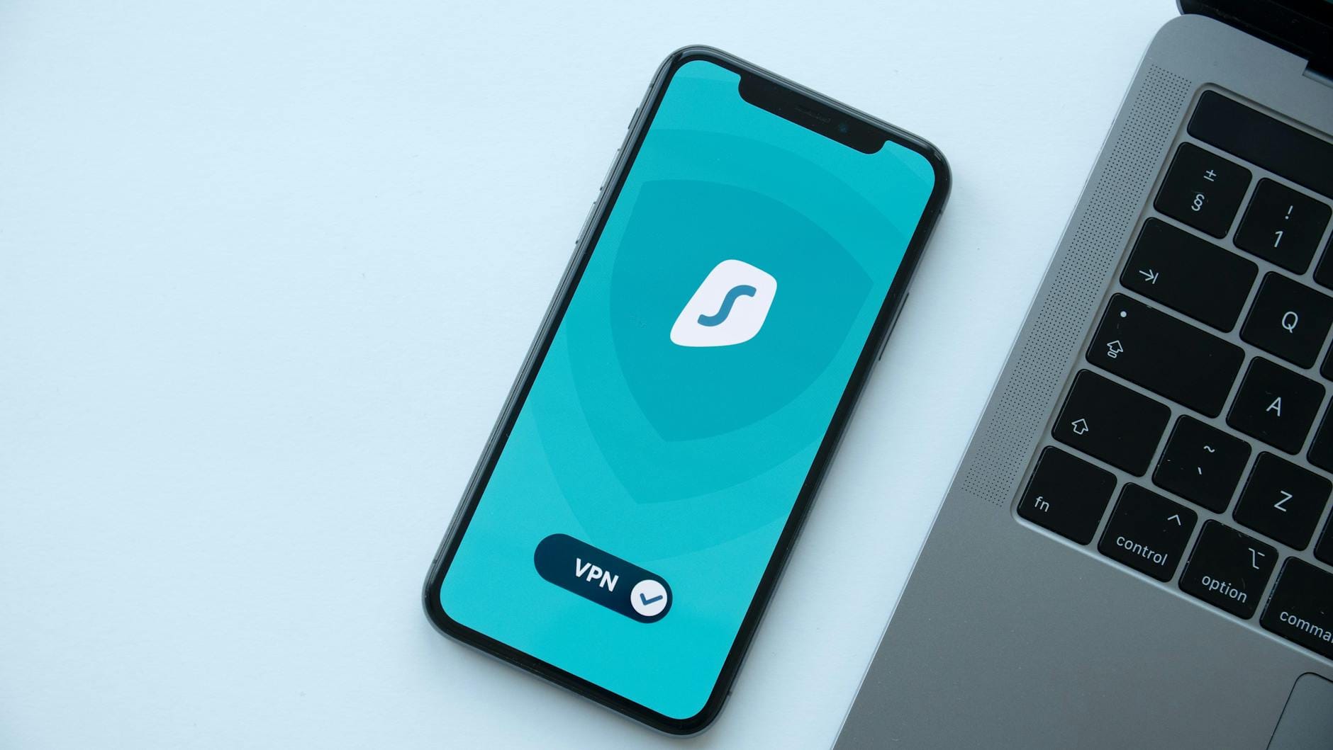 Smartfon z aplikacją VPN obok laptopa na biurku
