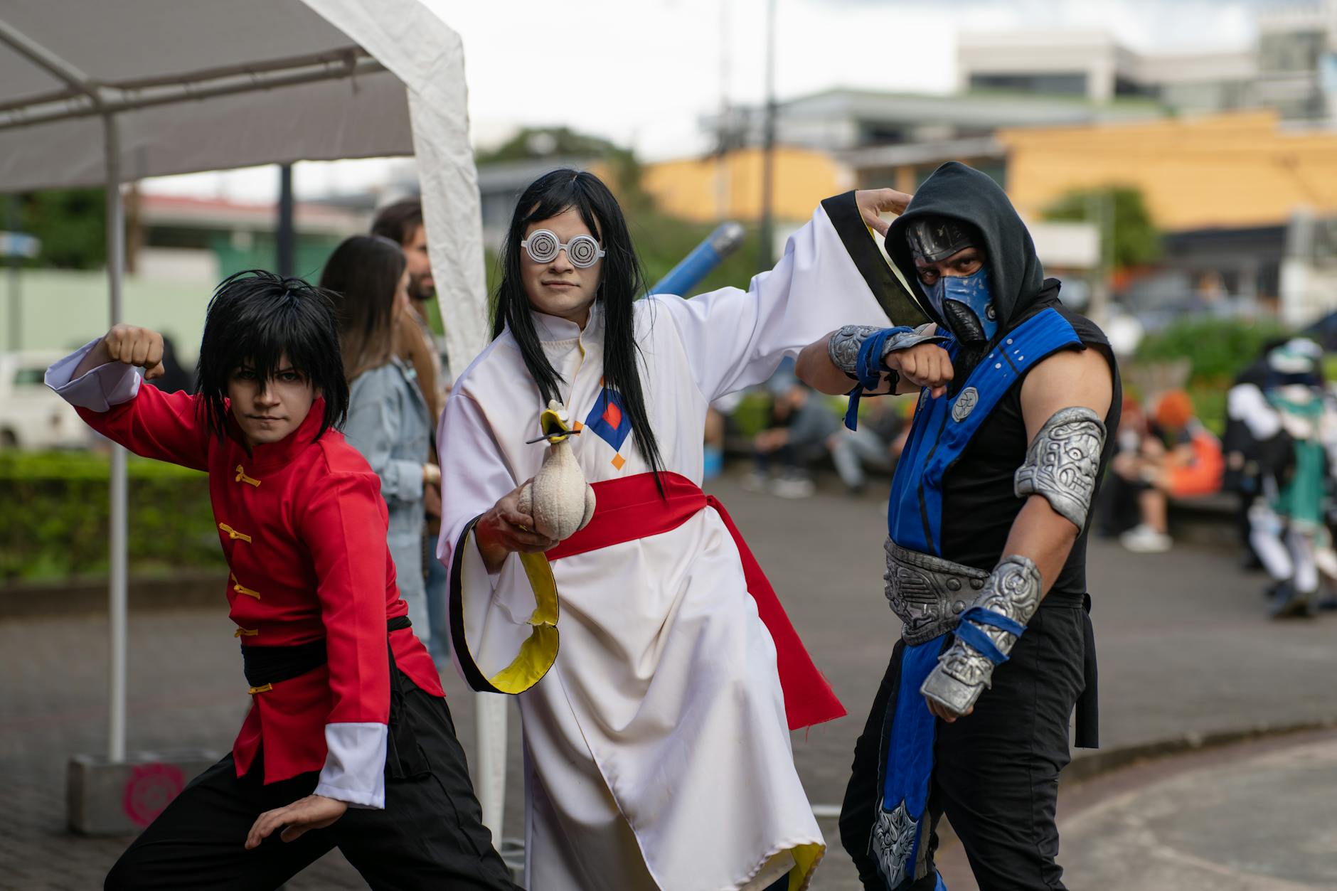 Trójka cosplayerów w strojach z anime pozuje na ulicy w San José
