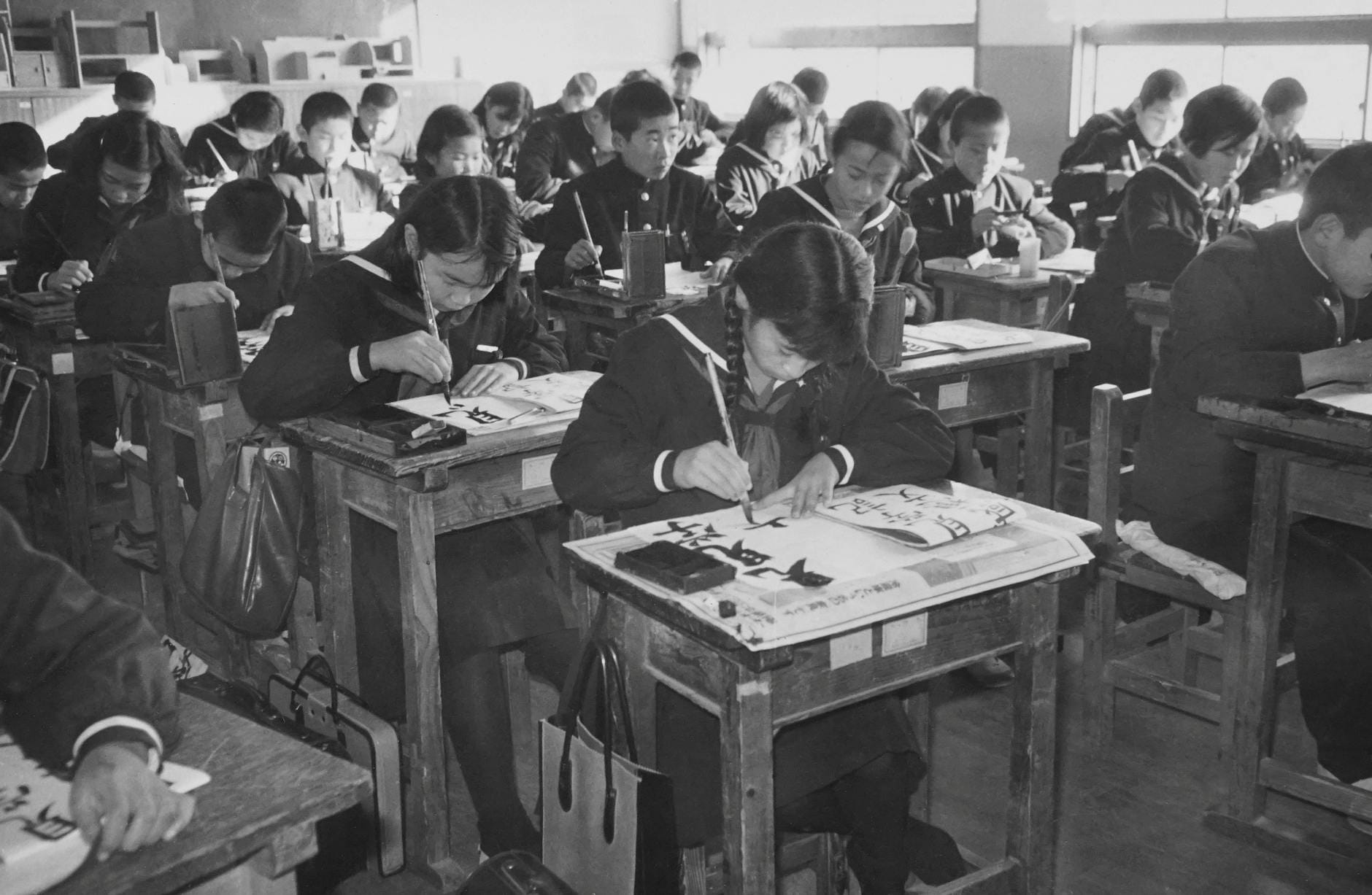 Co oznacza senpai i kohai? Zasady hierarchii w japońskiej szkole Uczniowie w japońskiej klasie ćwiczą kaligrafię na lekcji