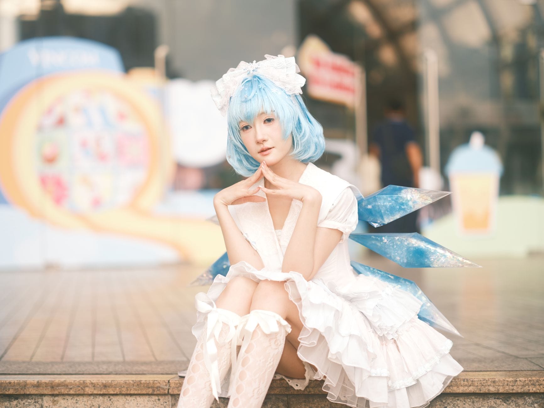 Cosplayerka o niebieskich włosach siedzi na zewnątrz w Wietnamie