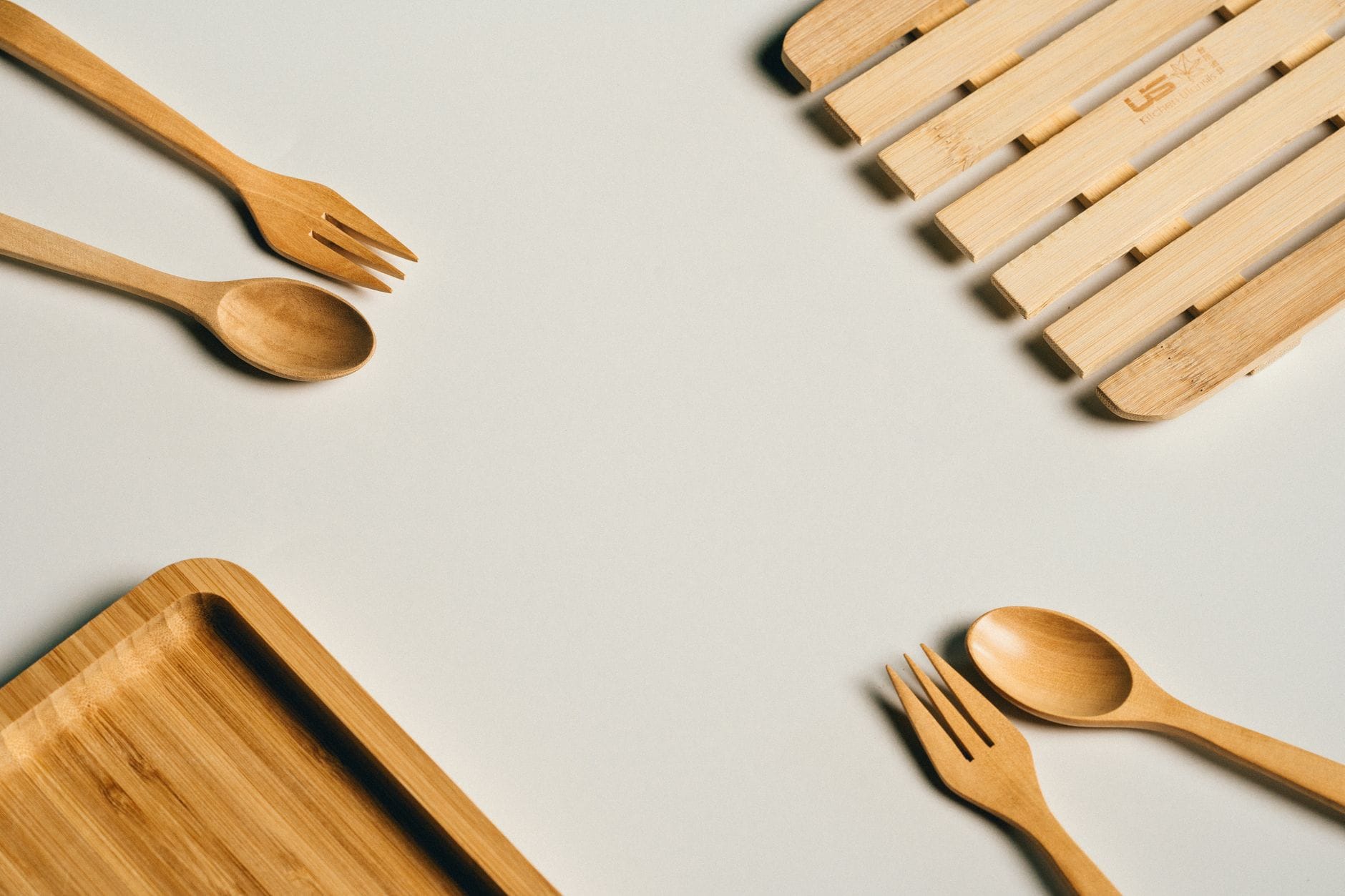 Bambusowy widelec, łyżka i taca na jasnym minimalistycznym tle