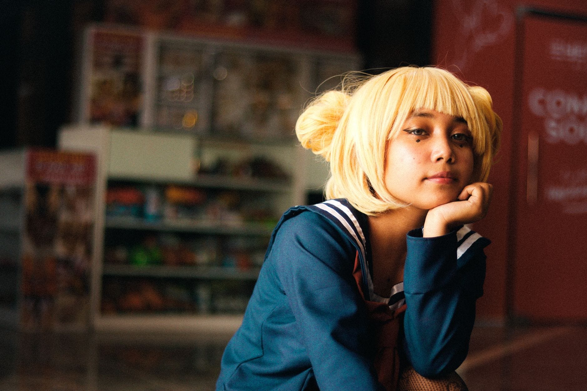Cosplayerka w blond peruce w szkolnym mundurku w pomieszczeniu