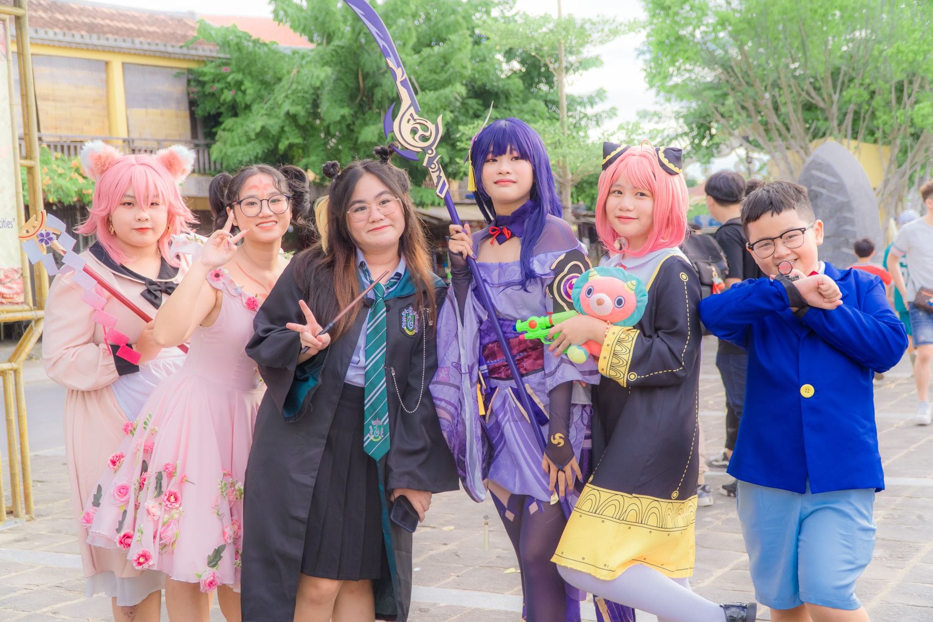 Grupa cosplayerów w kolorowych strojach pozuje na zewnątrz na evencie